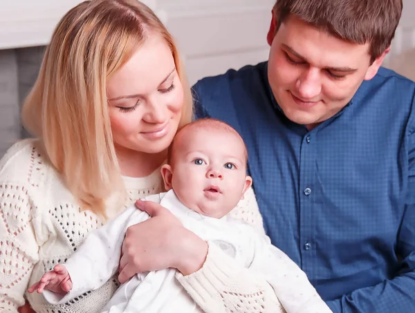 Porträt einer glücklichen Familie: Mutter, Vater und einjähriges Kind im Wohnzimmer — Stockfoto