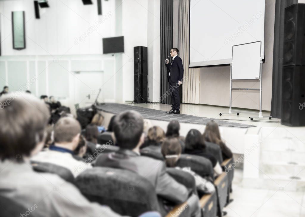 speaker speaks at a business conference in front of entrepreneurs and journalists