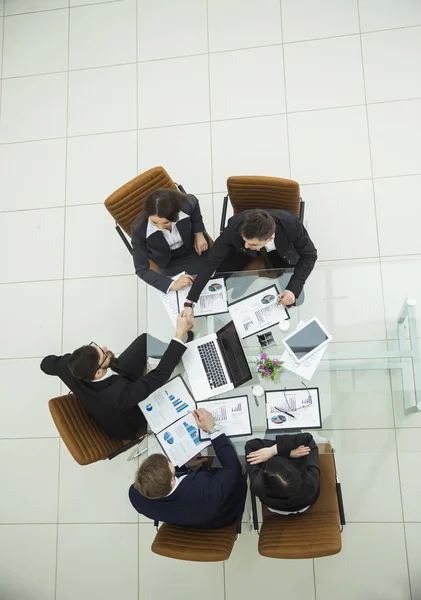 商业团队和可靠的商业伙伴在一张桌子上就新的金融合同进行辩论后握手 — 图库照片
