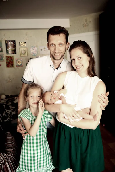 Retrato familiar - papá, hija y mamá con un bebé recién nacido — Foto de Stock