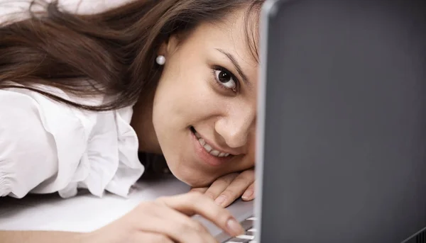 Närbild. leende ung kvinna med laptop på arbetsplatsen. — Stockfoto