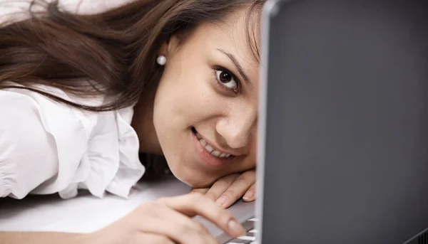 Closeup. smiling young woman with laptop in the workplace. Stock Picture