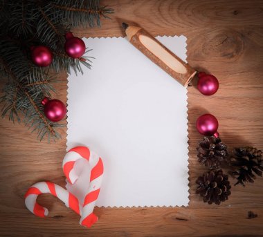 Boş Noel kartı, çam kozalakları ve tahta sırtlı kalem.