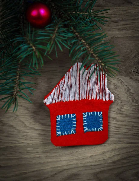 Concept of Christmas.knitted house and pine branch on wooden ba — Stock Photo, Image