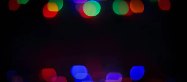 Wazig kleurrijke lampjes op een zwarte achtergrond .photo met kopiëren sp — Stockfoto