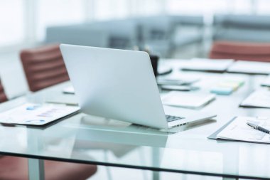 laptop ve üstünde okul sırası şirketin muhasebe bölümündeki belgeleri