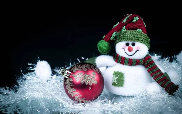 Διασκεδαστικό παιχνίδι χιονάνθρωπος και μπάλα Χριστουγεννιάτικη σε μαύρο φόντο. — Φωτογραφία Αρχείου