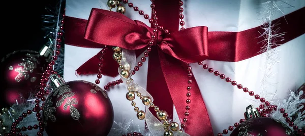 Коробка з різдвяним подарунком і різдвяними прикрасами на чорному — стокове фото