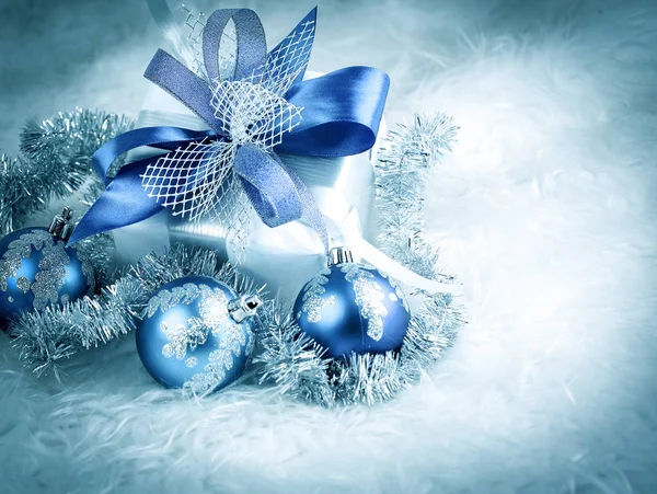 Regalo di Natale e palline di Natale blu su un dorso bianco festivo — Foto Stock