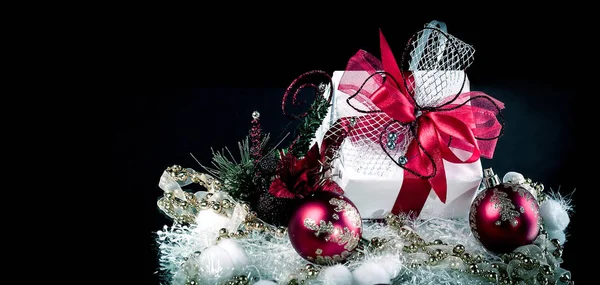 Regalo di Natale e palline di Natale rosse su sfondo nero. — Foto Stock