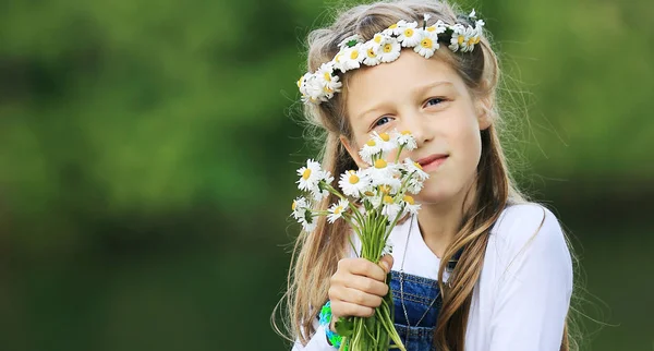 Πορτρέτο του χαριτωμένο μικρό κορίτσι σε ένα στεφάνι και ένα μπουκέτο από wildfl — Φωτογραφία Αρχείου