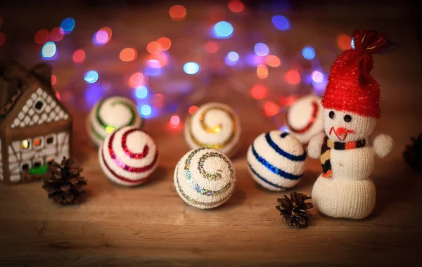Kerstballen en een speelgoed sneeuwpop op kersttafel — Stockfoto