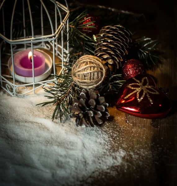 Christmas candle and festive accessories on a black background. — Stock Photo, Image