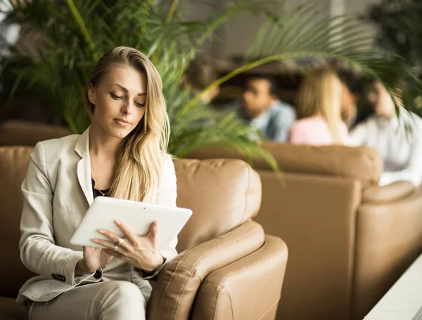 Iş kadını kanepede oturan bir dijital tablet ile — Stok fotoğraf