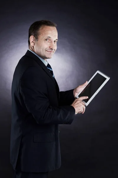 Ein erfolgreicher, selbstbewusster Geschäftsmann prüft einen Vertrag auf einem Tablet — Stockfoto