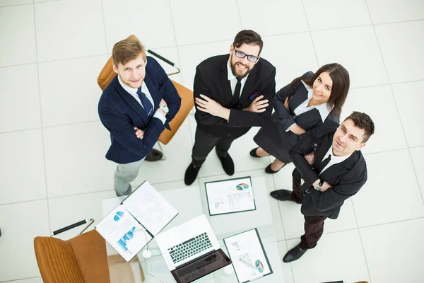 Equipo de negocios exitoso de pie uno al lado del otro cerca del lugar de trabajo en la oficina — Foto de Stock