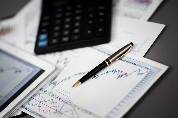 Tableta, calculadora, pluma y gráficos financieros en el hombre de negocios del lugar de trabajo —  Fotos de Stock
