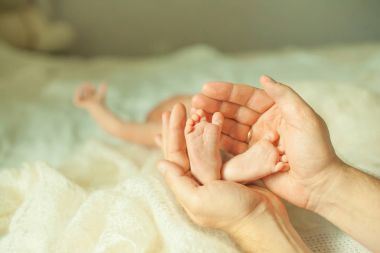 .Yeni doğmuş bir bebek bacakları sarılma mutlu anne.