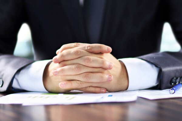 Крупный план бизнесмен подписывает документы на рабочем месте в офисе
