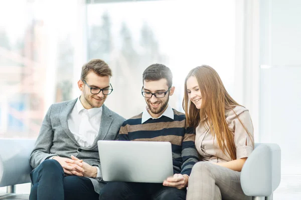 Mitarbeiter mit Laptop sitzen in der Lobby des Büros — Stockfoto