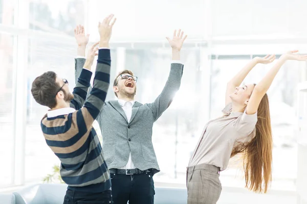 Концепция победы - ликующая деловая команда, стоящая в кругу, руки вверх в радости успеха . Лицензионные Стоковые Фото