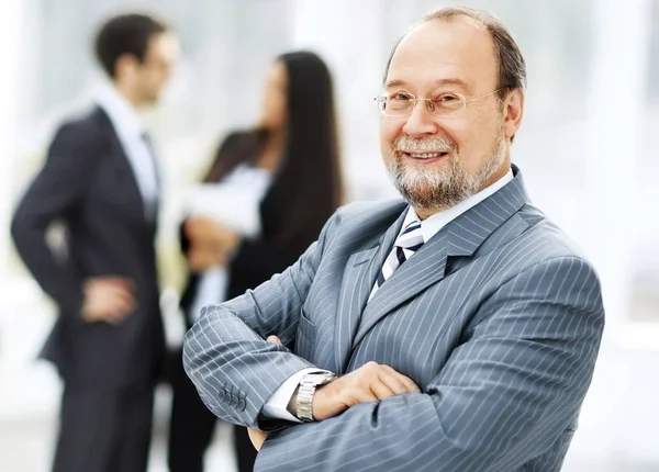Portret van een succesvolle zakenman op de achtergrond van het werk van zijn ploeg — Stockfoto