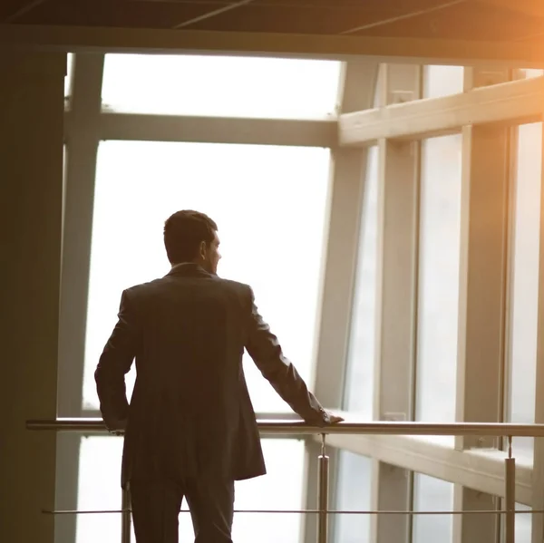 Empresario mirando por la ventana pensando en ideas de negocios —  Fotos de Stock