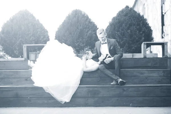 Photo.bride en blanco y negro y el novio descansando en un podio de madera — Foto de Stock