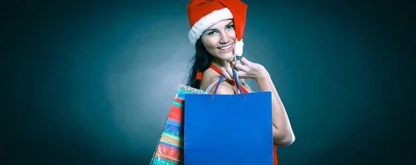 Feliz jovem mulher vestida como Papai Noel com o sho de Natal — Fotografia de Stock