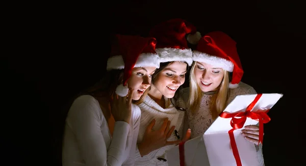 Grupo de estudantes do sexo feminino em trajes de Papai Noel abrindo um b — Fotografia de Stock