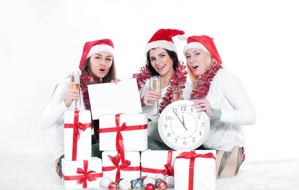 Três jovens mulheres em chapéus de Papai Noel com presentes de Natal f — Fotografia de Stock