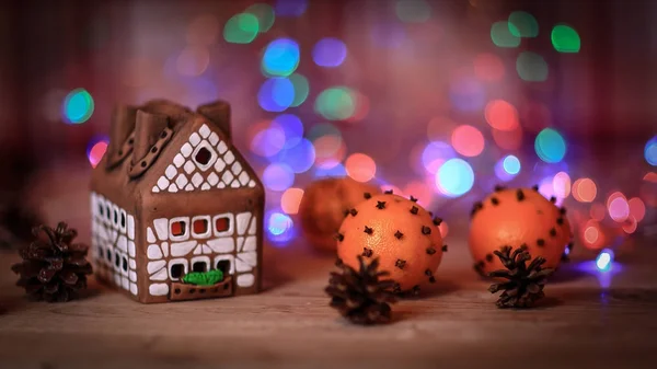 Peperkoekenhuis en sinaasappels aan de kersttafel — Stockfoto