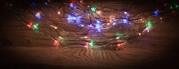 Χριστουγεννιάτικο δέντρο γιρλάντα απλωμένη σε ένα ξύλινο τραπέζι — Φωτογραφία Αρχείου