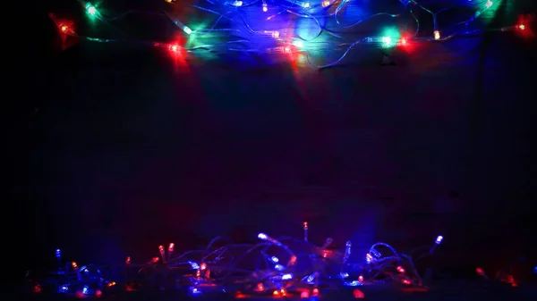 Girlande mit bunten Lichtern auf schwarzem Hintergrund — Stockfoto