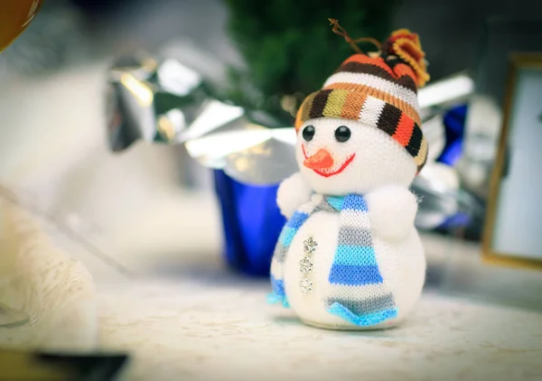 Lindo muñeco de nieve juguete y tarjeta de felicitación en la mesa de Navidad —  Fotos de Stock