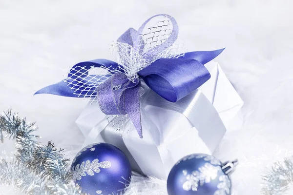 Regalo di Natale e palline di Natale blu su un dorso bianco festivo — Foto Stock