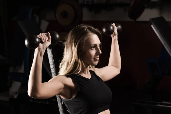 Affärskvinna gör övning på en fitness-maskin i ett gym — Stockfoto