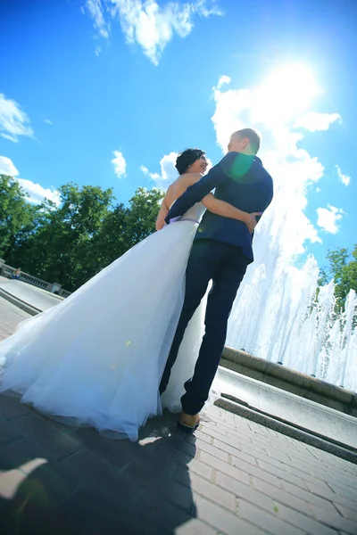 Bruid en bruidegom, staande in het stadsplein op een zonnige dag. — Stockfoto