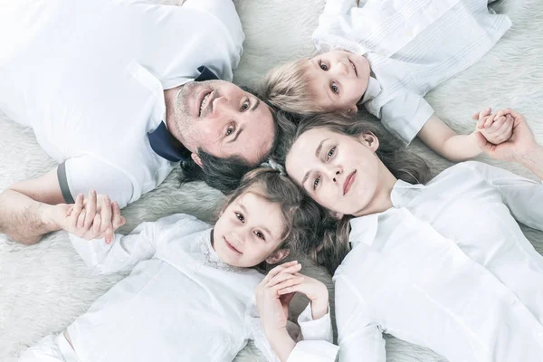 Concepto de felicidad familiar: familia feliz relajarse en la alfombra el domingo — Foto de Stock