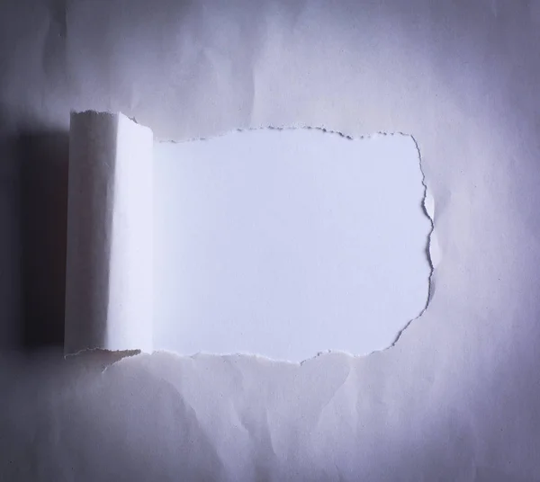 Hål i papperet med trasiga edges.background. — Stockfoto