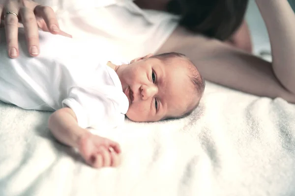 Begreppet mödra - nyfödd baby med mamma om på sängen — Stockfoto