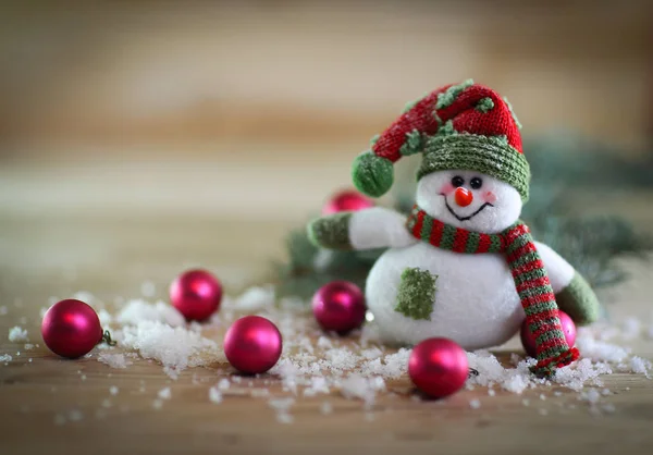 Vánoční přání. hračka sněhulák na slavnostní pozadí. — Stock fotografie