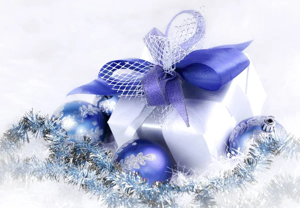 Christmas gift and blue Christmas balls on a festive white back — Stock Photo, Image