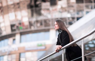 Modern bir ofis binasına karşı kendine güvenen bir iş kadınının portresi