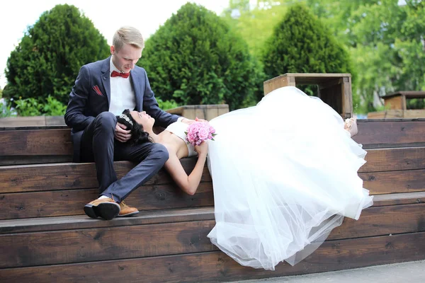 Couple aimant assis sur un banc le jour du mariage . — Photo