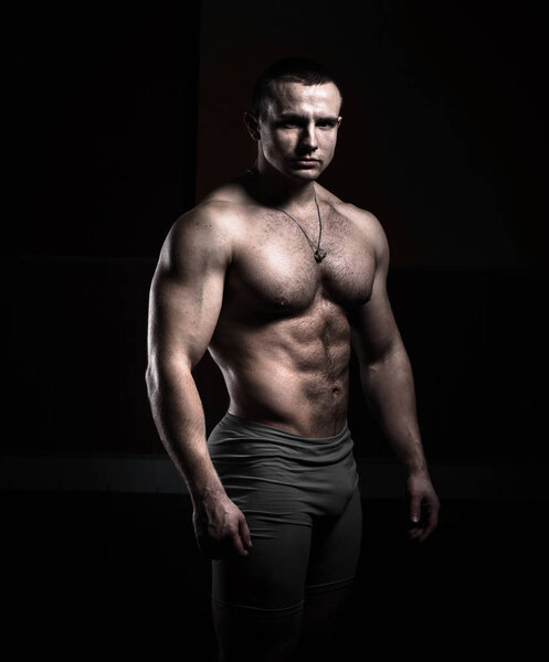 Портрет культуриста на черном фоне
