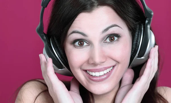 Cheerful young woman listening to music through headphones . — Stock Photo, Image