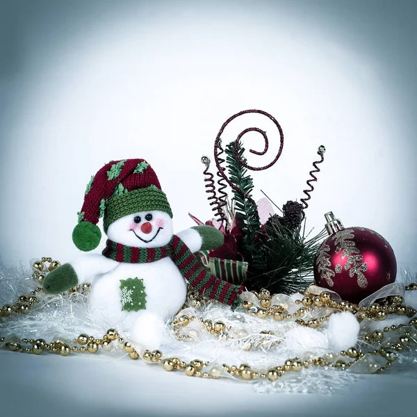 Niedliches Spielzeug Schneemann und verschiedene Weihnachtsdekorationen auf einem weißen b — Stockfoto
