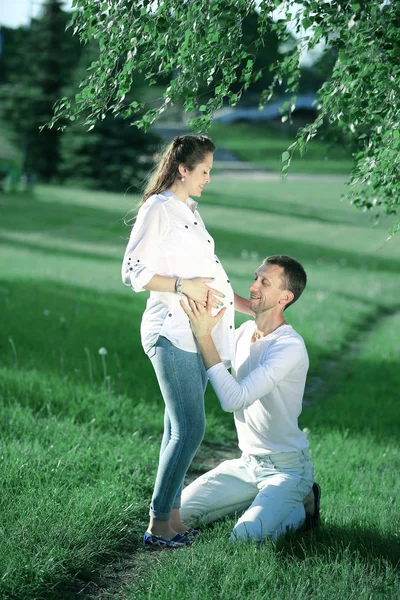 Gelukkig man omarmen zijn zwangere vrouw op een wandeling in het Park — Stockfoto