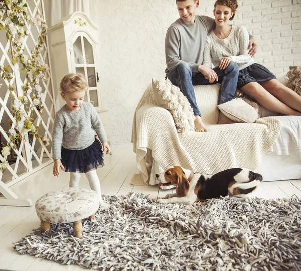 Feliz familia joven descansando en la sala de estar el domingo — Foto de Stock